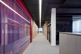 Als Kontrast zu der markanten CI Farbe kommen schwarze mobile Boxen sowie holzverkleidete Meeting-Räume zum Einsatz. Foto: bkp - Annika Feuss Fotografie 